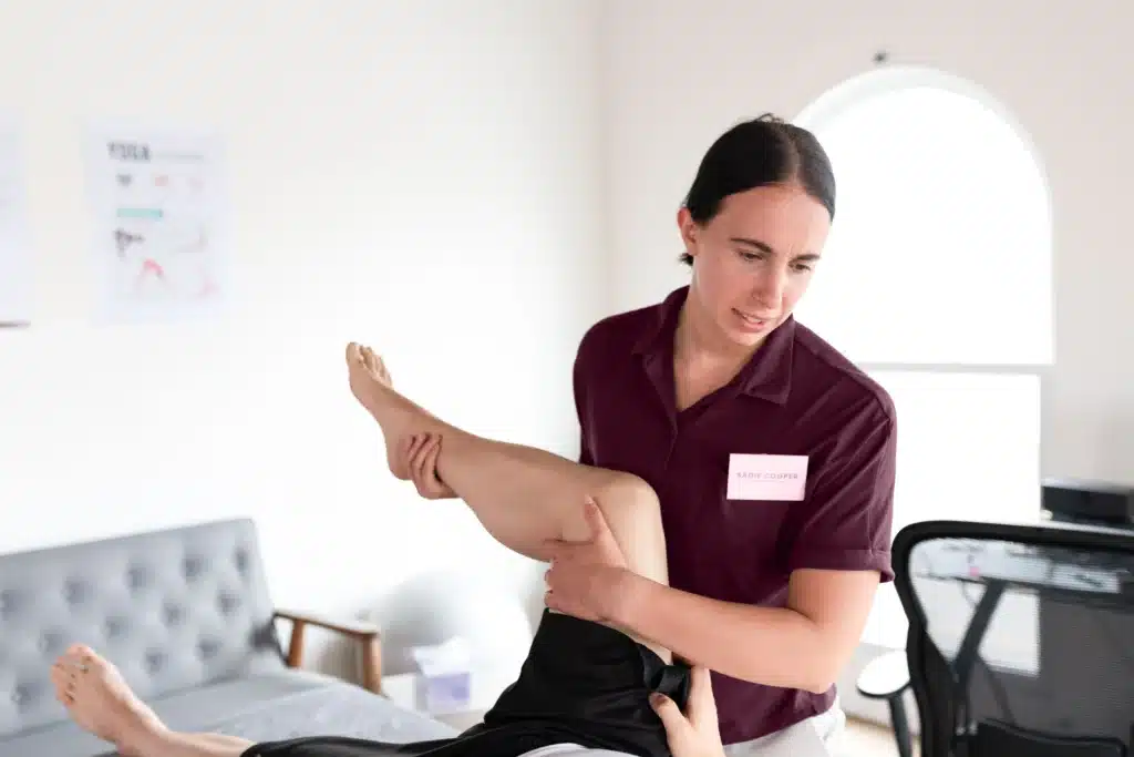 Platinum PT physical therapist stretching a patient's leg during a session in the clinic