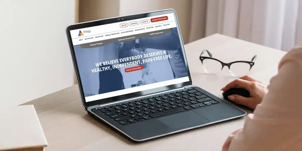 Laptop displaying the Trilogy Physical Therapy website homepage